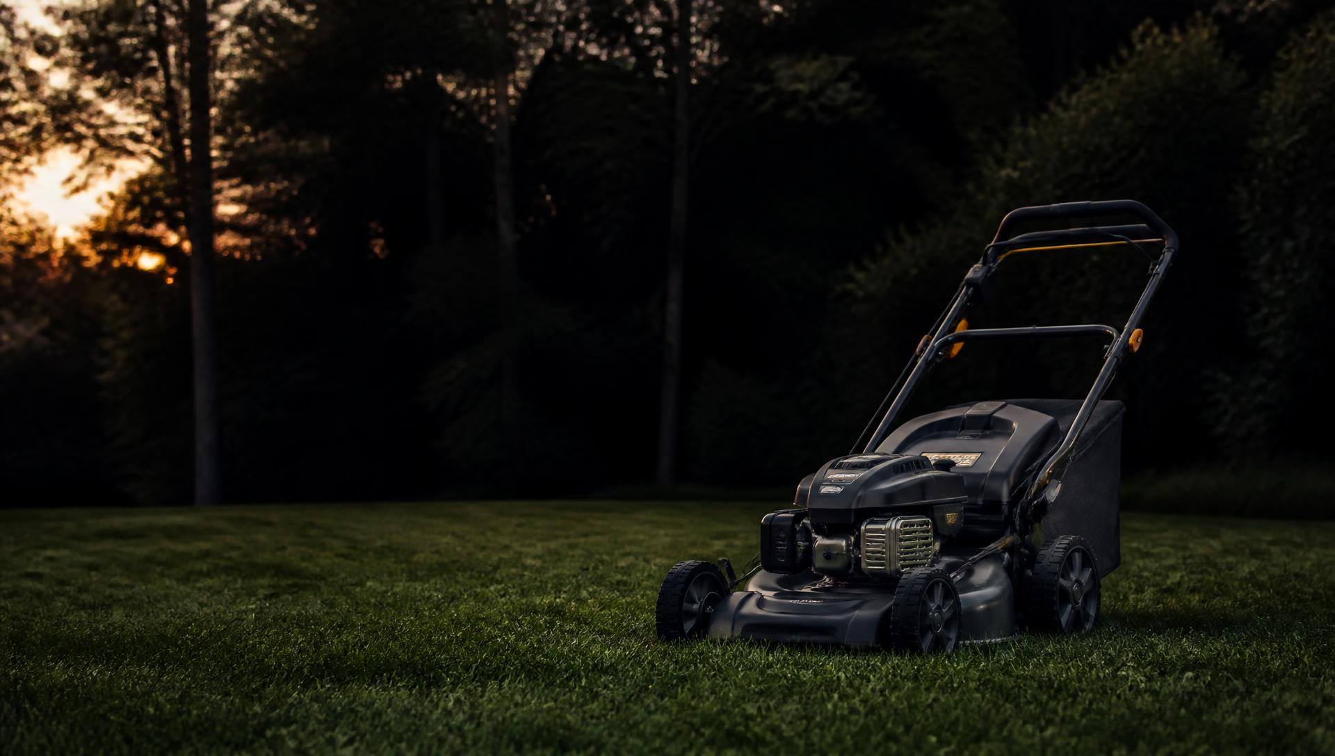 Lawn mower on freshly cut grass at dusk